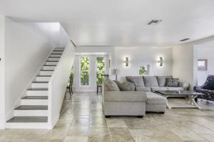 Holley House home في كابتيفا: غرفة معيشة مع أريكة ودرج