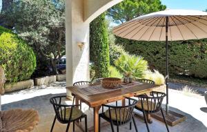 a wooden table and chairs with an umbrella at La Maison De Nelly in Paradou +22 photos