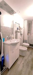 La salle de bains blanche est pourvue d'un lavabo et de toilettes. dans l'établissement Mirdita - Casa Vacanze, à La Spezia
