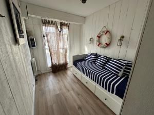 1 dormitorio con 1 cama con almohadas de rayas azules y blancas en Ker Lafranec'h - Face Mer et Plage, 2 Chambres, WiFi, en Saint-Pierre-Quiberon