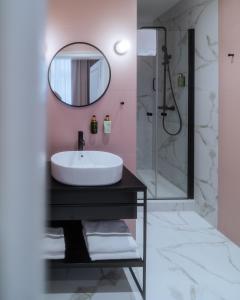 a bathroom with a sink and a mirror at Hotel Pietryna in Łódź