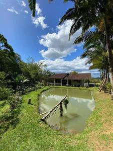 a boat in a pond in front of a house at casa do lago, paz e sossego. in Guaramirim