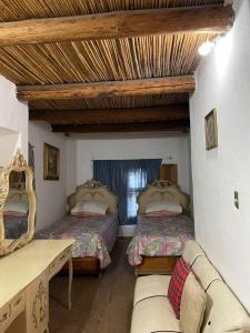 ein Wohnzimmer mit 2 Betten und einem Sofa in der Unterkunft Ventana Al Desierto in Real de Catorce