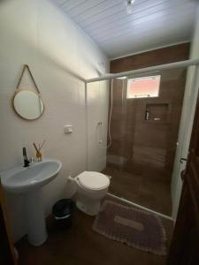 a bathroom with a shower and a toilet and a sink at casa do lago, paz e sossego. in Guaramirim