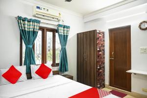 a bedroom with a bed with red pillows and a window at OYO Flagship Shraddha Residency 2 in Kolkata