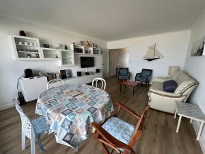 sala de estar con mesa, sillas y sofá en Ker Lafranec'h - Face Mer et Plage, 2 Chambres, WiFi, en Saint-Pierre-Quiberon