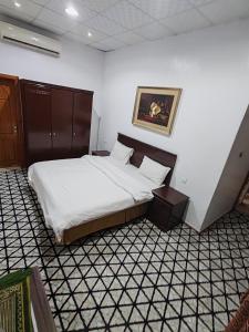 a bedroom with a bed and a picture on the wall at منتجع الريحانه فلة رقم ٢ in Al Wahţ