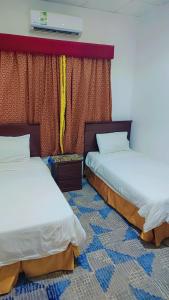 a room with two beds and a window at منتجع الريحانه فلة رقم ٢ in Al Wahţ