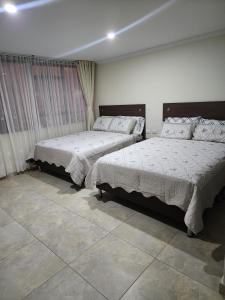 a bedroom with two beds and a tiled floor at HOTEL CASA MARED Corferias-Embajada Americana in Bogotá