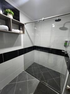 a bathroom with a shower with black and white tiles at HOTEL CASA MARED Corferias-Embajada Americana in Bogotá