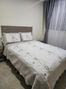 a bedroom with a bed with a white comforter at HOTEL CASA MARED Corferias-Embajada Americana in Bogotá