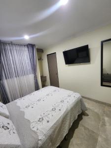 a bedroom with a bed and a flat screen tv at HOTEL CASA MARED Corferias-Embajada Americana in Bogotá