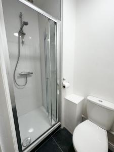 a white bathroom with a shower and a toilet at Flat B, Stay In Earlsfield in London