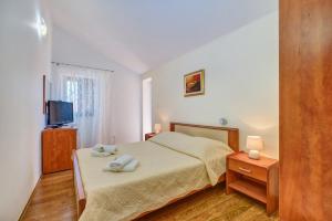 マルティンスシカにあるApartments by the sea Martinscica, Cres - 22582のベッドルーム1室(ベッド1台、タオル2枚付)