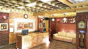 a lobby with a couch and a clock on the wall at Antigua Inn Hotel in Guatemala