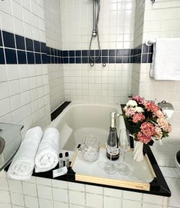 a bathroom with a bath tub with flowers and wine glasses at Apartamento Copa Dreams HIR 11 in Rio de Janeiro