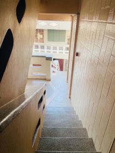 a hallway with stairs leading up to a building at Tuxedo Hotel in Accra