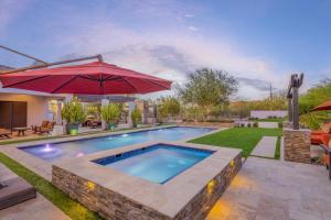 una piscina en un patio con sombrilla en Luxury Estate, Heated Pool, Spa, Game Room, More en Scottsdale