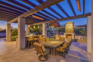 eine Terrasse mit einem Holztisch und Stühlen sowie einem Kamin in der Unterkunft Luxury Estate, Heated Pool, Spa, Game Room, More in Scottsdale