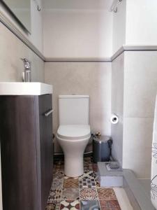 uma casa de banho com um WC e um lavatório em Aegina Port Apt 3 em Egina