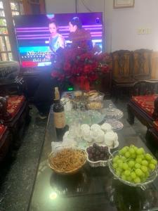 una mesa con tazones de comida y una TV en Thịnh Nhàn motel en Móng Cái