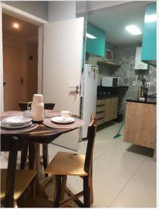 a kitchen with a table with chairs and a refrigerator at Apartamento Na Praia - VG FUn residence in Fortaleza