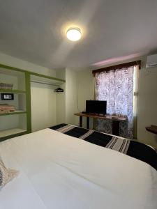 a bedroom with a white bed and a window at Hotel Koox Jool Bacalar in Bacalar
