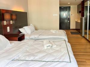 2 Betten in einem Hotelzimmer mit Handtüchern darauf in der Unterkunft SCSP 689 Premium SBR2B Near Imago and KKIA in Kota Kinabalu