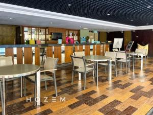 ein Restaurant mit Tischen und Stühlen und eine Bar in der Unterkunft SCSP 689 Premium SBR2B Near Imago and KKIA in Kota Kinabalu