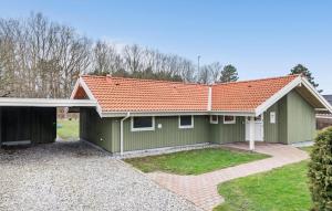 una casa verde con techo naranja en Nice Home In Dannemare With 3 Bedrooms, Sauna And Wifi, en Dannemare