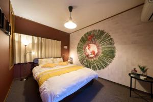 een slaapkamer met een groot bed en een schilderij aan de muur bij 花の宿　別府・鉄輪 in Beppu