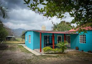 una casa azul con un adorno rojo en Casa de campo - Ruta Turquesa, en El Naranjo