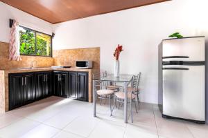 a kitchen with a table and a refrigerator at Rio Celeste, Aire Acondicionado, Comodidad in Upala