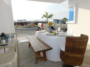 einen Tisch mit einem weißen Tischtuch und einer Bank in der Unterkunft Casa Florencia gran piscina in Salinas