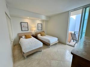 a bedroom with two beds and a balcony at The King David Condos in Miami Beach