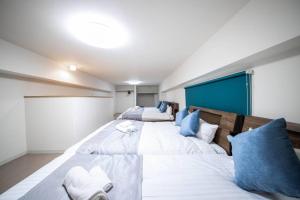 een slaapkamer met 2 grote bedden met blauwe kussens bij East Avenue 601 in Sapporo