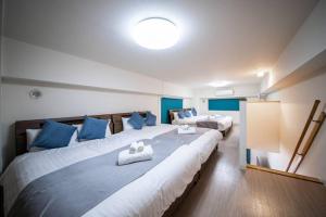 een slaapkamer met twee bedden met blauwe kussens erop bij East Avenue 601 in Sapporo