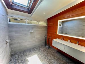 ein Bad mit einem Waschbecken und einem Spiegel in der Unterkunft Taunoa House - Family seaside house in Papeete with HS Wifi in Papeete