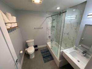 y baño con ducha, aseo y lavamanos. en The Comfy Suite - 1BR with Free Parking, en Paterson