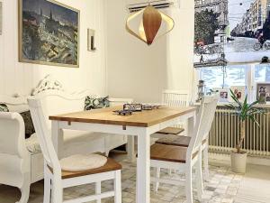 un comedor blanco con mesa de madera y sillas en Holiday home ÅBY, en Åby