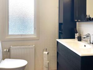 La salle de bains est pourvue de toilettes, d'un lavabo et d'une fenêtre. dans l'établissement Holiday home HÄLLEKIS, à Lugnås