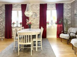une salle à manger avec une table et des rideaux rouges dans l'établissement Holiday home HÄLLEKIS, à Lugnås