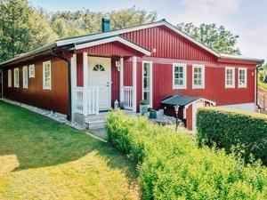 ein rotes Haus mit einer weißen Tür und einem Hof in der Unterkunft Holiday home HÖÖR II in Höör