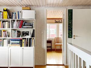 a room with white book shelves filled with books at 4 star holiday home in GRISSLEHAMN-By Traum in Grisslehamn