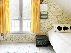 a bedroom with yellow curtains and a bed and a window at 4 star holiday home in GRISSLEHAMN-By Traum in Grisslehamn