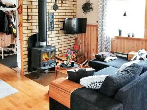 a living room with a couch and a fireplace at 7 person holiday home in Oviken-By Traum in Gräftåvallen +9 photos