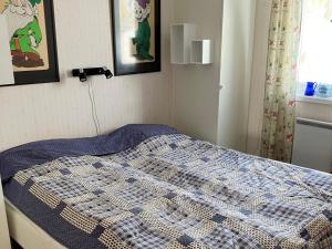 a bedroom with a bed with a blue and white quilt at Holiday home SUNNE IV in Sunne