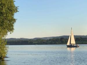 a sailboat on a large lake in the water at Holiday home SUNNE IV in Sunne
