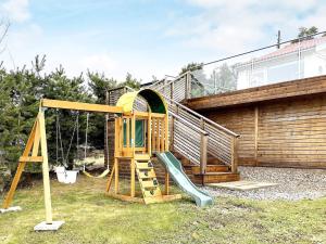 un parque infantil con tobogán y columpio en Holiday home UDDEVALLA XIX, en Sundsandvik