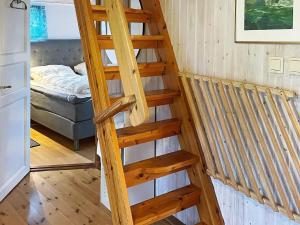 una escalera de madera en una casa pequeña con cama en Holiday home Ronneby XIII, en Ronneby